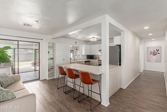 430 N Vineyard, Mesa, AZ 85201 - kitchen with a kitchen bar, visible vents, a sink, a peninsula, and stainless steel appliances