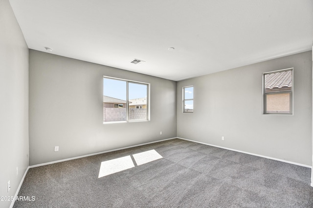 unfurnished room featuring visible vents, baseboards, and carpet