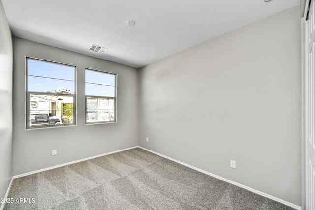 carpeted spare room with baseboards and visible vents