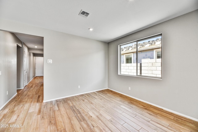 spare room with visible vents, baseboards, and light wood finished floors