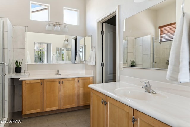 full bathroom featuring a sink, two vanities, a shower stall, and tile patterned floors