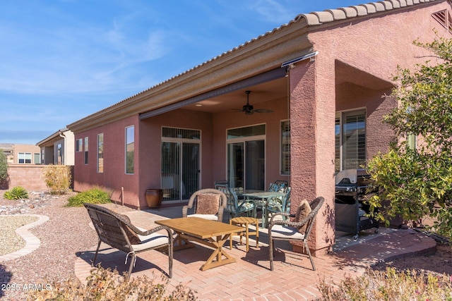 view of patio featuring outdoor dining space, a grill, fence, and ceiling fan