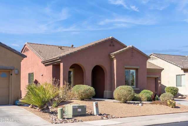 view of front of home with stucco siding, driveway, an attached garage, and a tile roof