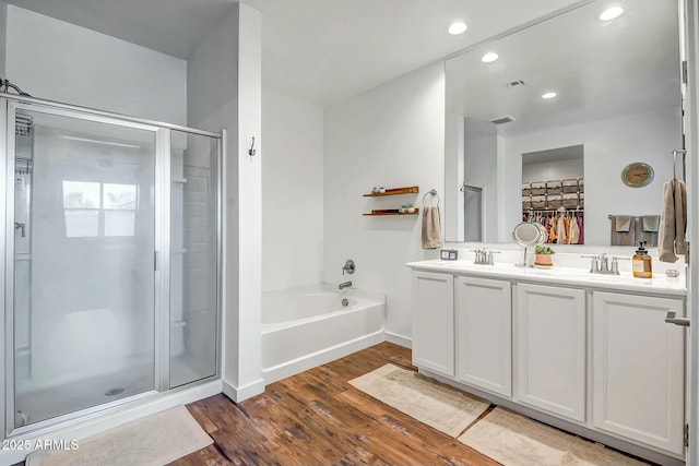 bathroom with wood-type flooring, shower with separate bathtub, and vanity