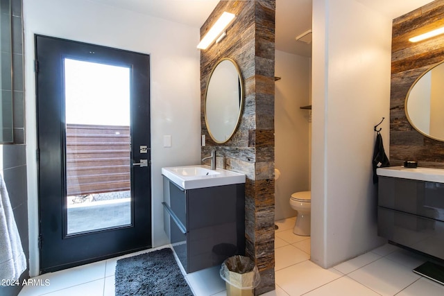 bathroom featuring plenty of natural light, toilet, tile patterned flooring, and vanity