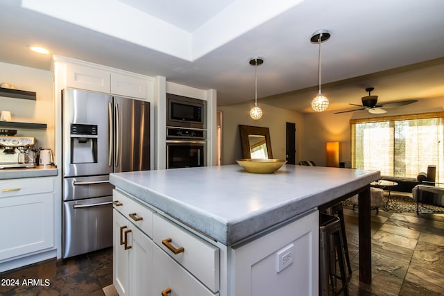 kitchen featuring white cabinetry, appliances with stainless steel finishes, a center island, and pendant lighting