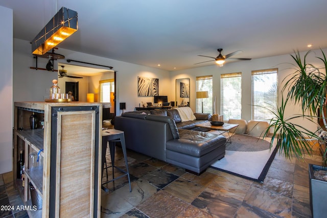 living room featuring bar area and ceiling fan