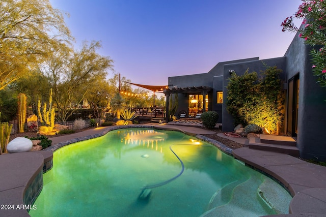 pool at dusk featuring a patio area