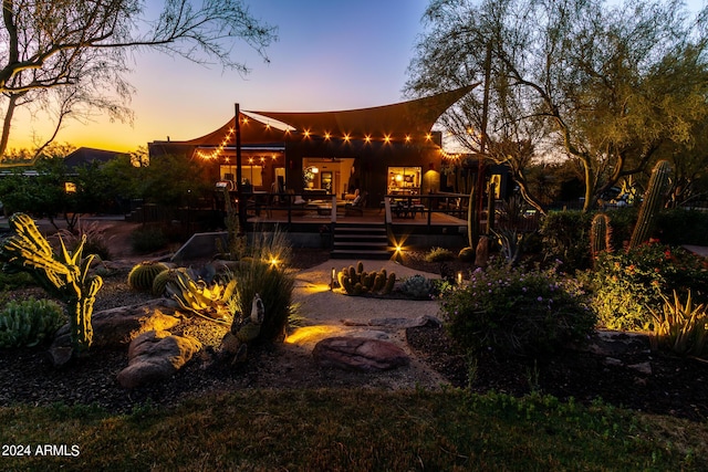 back house at dusk with a deck