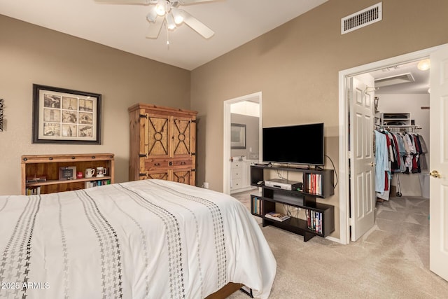 bedroom featuring ensuite bath, light colored carpet, ceiling fan, a spacious closet, and a closet