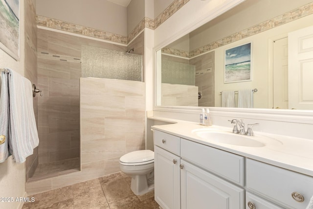 bathroom featuring toilet, vanity, and tiled shower