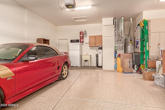 garage with white fridge, sink, a garage door opener, and water heater