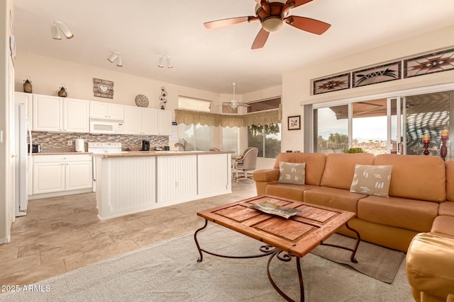 living room featuring ceiling fan and sink