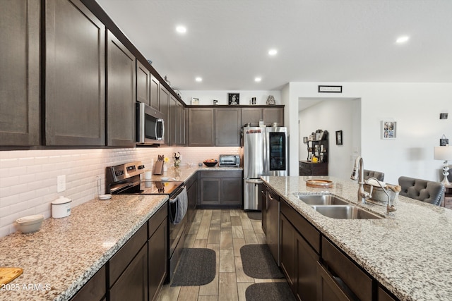 1135 E Barrus Dr, Casa Grande, AZ 85122 - kitchen with wood tiled floor, tasteful backsplash, a sink, and stainless steel appliances