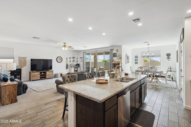 1135 E Barrus Dr, Casa Grande, AZ 85122 - kitchen with a sink, light stone countertops, a kitchen bar, stainless steel dishwasher, and visible vents
