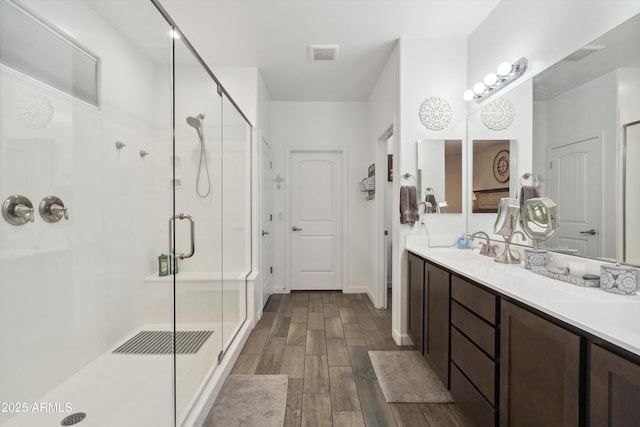 1135 E Barrus Dr, Casa Grande, AZ 85122 - bathroom featuring vanity, visible vents, wood finished floors, and a shower stall