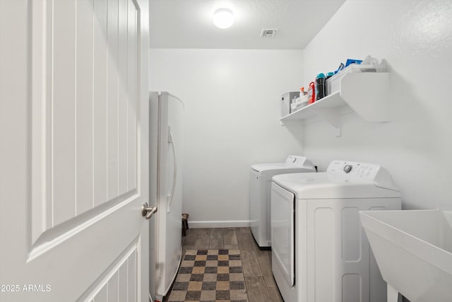 1135 E Barrus Dr, Casa Grande, AZ 85122 - clothes washing area with washer and clothes dryer, a sink, visible vents, laundry area, and wood tiled floor