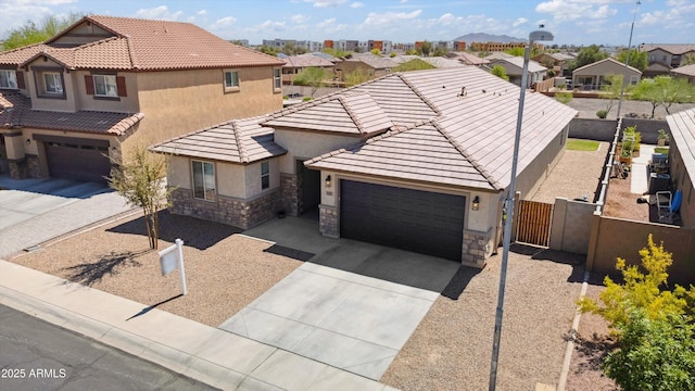 1135 E Barrus Dr, Casa Grande, AZ 85122 - view of front facade with driveway, stone siding, stucco siding, fence, and an attached garage