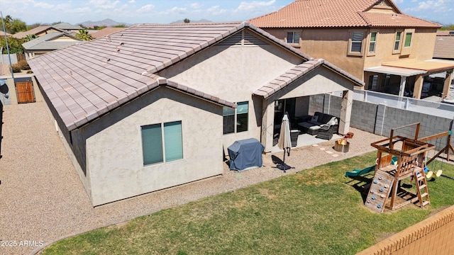 1135 E Barrus Dr, Casa Grande, AZ 85122 - rear view of property featuring a tile roof, stucco siding, a fenced backyard, a patio, and a playground