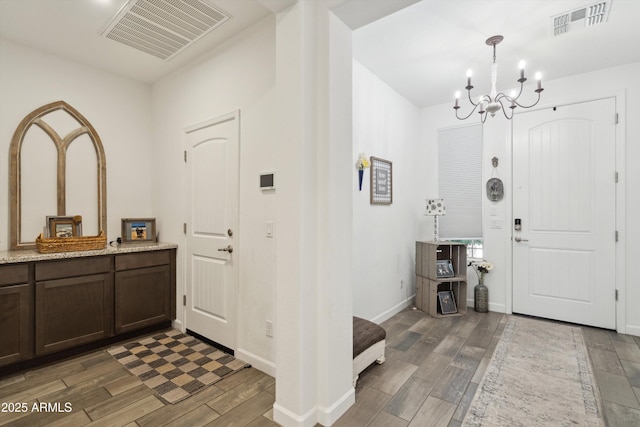 1135 E Barrus Dr, Casa Grande, AZ 85122 - entryway featuring baseboards, visible vents, a notable chandelier, and wood finished floors
