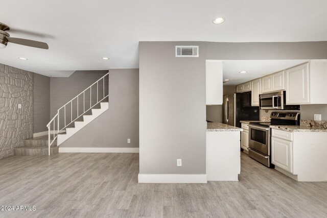 kitchen featuring appliances with stainless steel finishes, light hardwood / wood-style flooring, white cabinetry, and light stone countertops