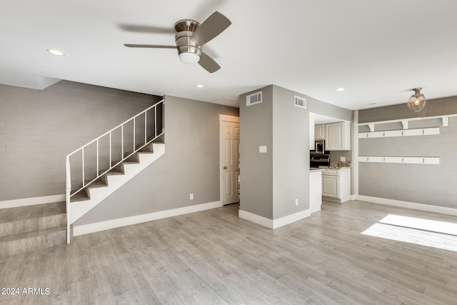 unfurnished living room featuring light hardwood / wood-style floors and ceiling fan