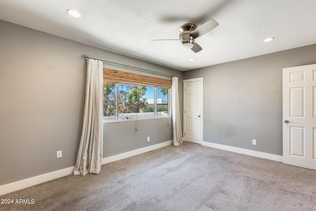 unfurnished room with ceiling fan and carpet