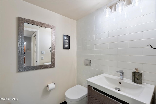 bathroom featuring toilet, backsplash, and vanity