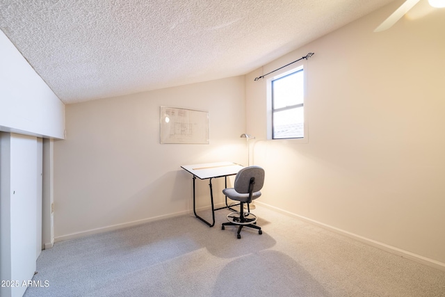 carpeted home office featuring ceiling fan, vaulted ceiling, and a textured ceiling