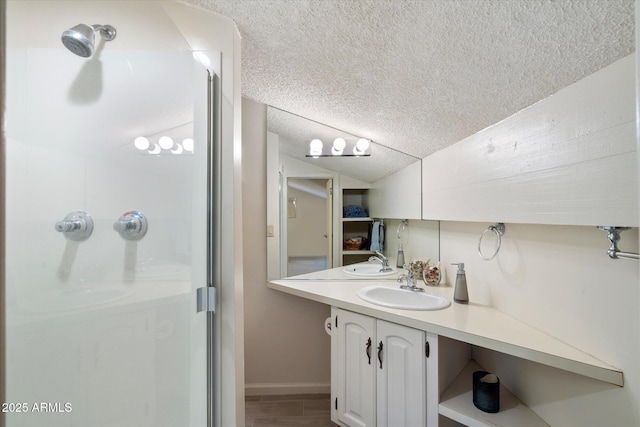 bathroom featuring a shower with shower door, a textured ceiling, and vanity