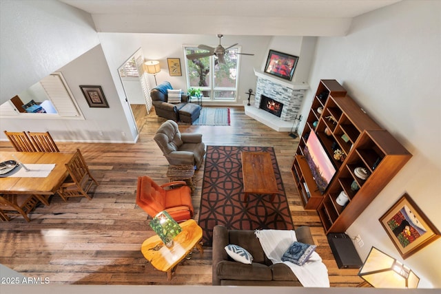 living room with ceiling fan, a fireplace, and dark hardwood / wood-style floors