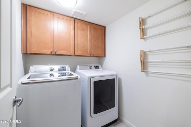 laundry room featuring cabinets and separate washer and dryer