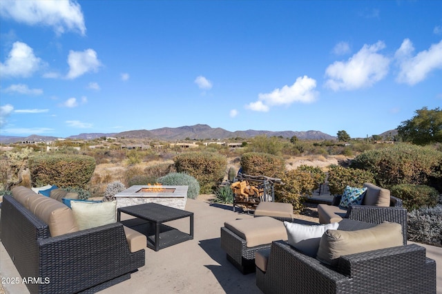 view of patio / terrace with an outdoor living space with a fire pit and a mountain view