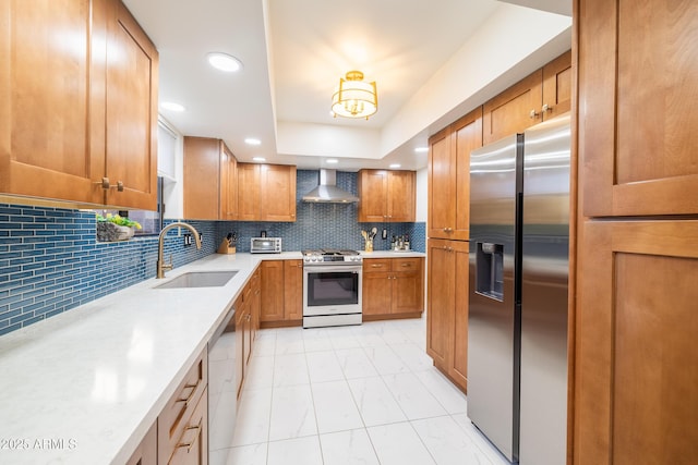 kitchen with backsplash, wall chimney exhaust hood, sink, and stainless steel appliances