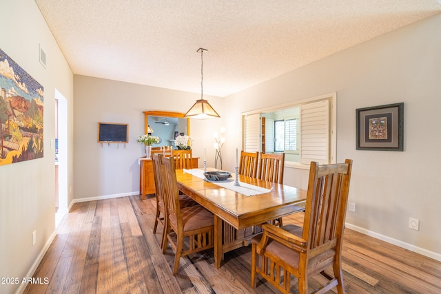 dining space with a textured ceiling and dark hardwood / wood-style floors