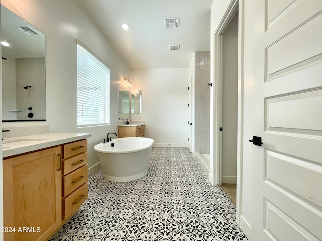 bathroom with plus walk in shower, vanity, and tile patterned floors