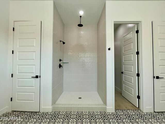 bathroom with tile patterned flooring and a tile shower