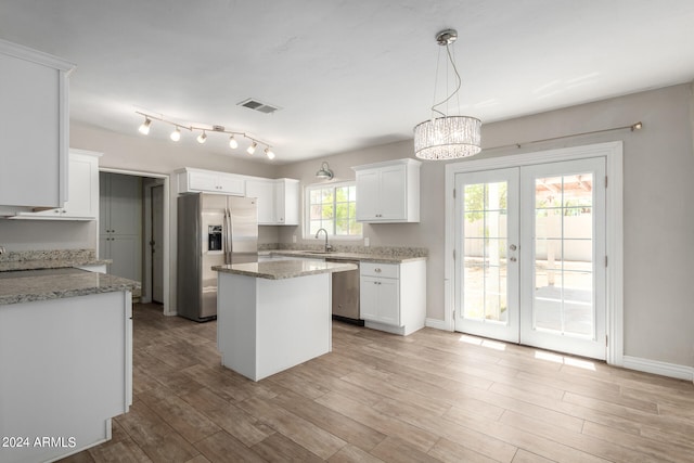 kitchen featuring white cabinets, appliances with stainless steel finishes, sink, and a center island