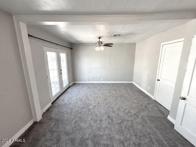 carpeted spare room with ceiling fan and french doors