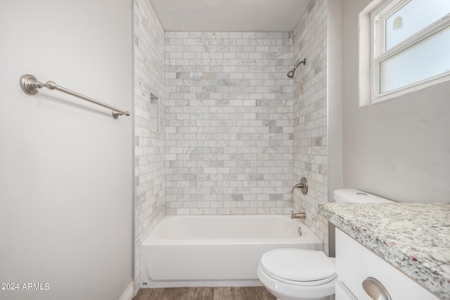 full bathroom with toilet, vanity, and tiled shower / bath