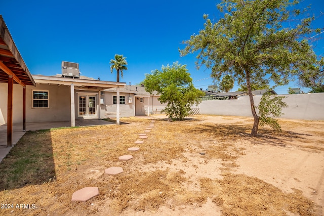 view of yard featuring cooling unit, french doors, and a patio