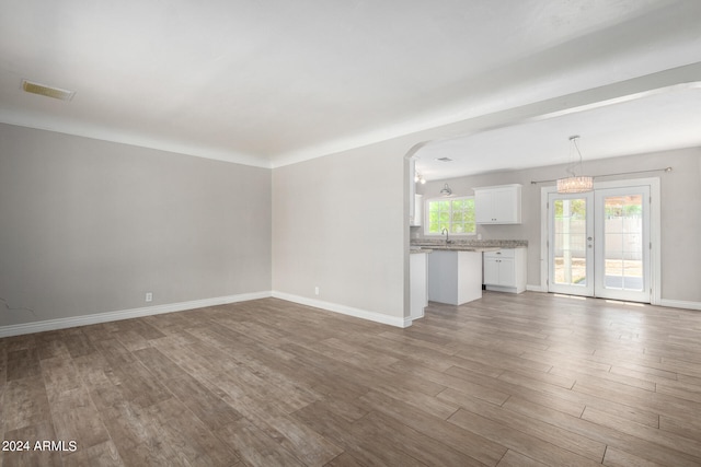 unfurnished living room with wood-type flooring and sink