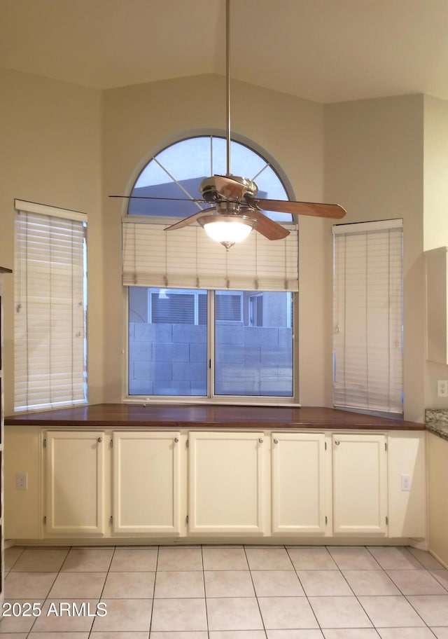 kitchen with white cabinetry, light tile patterned floors, and ceiling fan