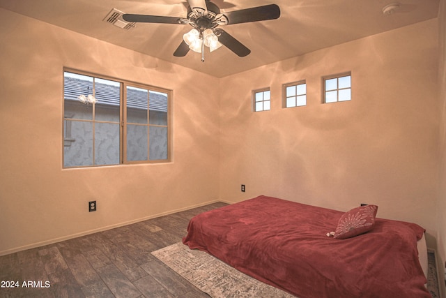 bedroom with dark hardwood / wood-style floors and ceiling fan