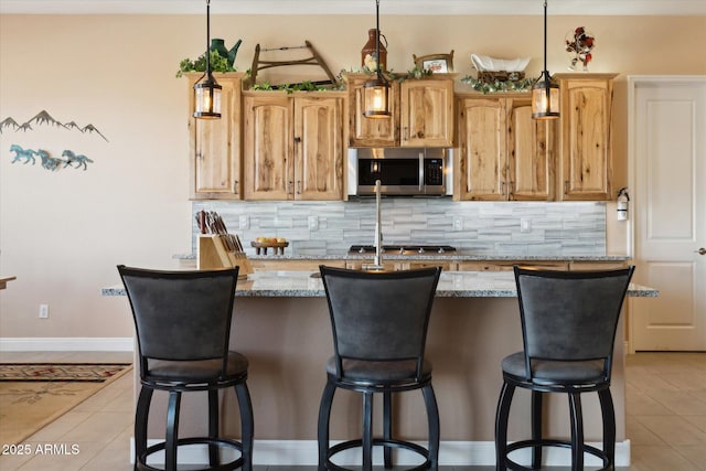 kitchen with light tile patterned floors, tasteful backsplash, hanging light fixtures, and light stone countertops