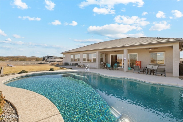 view of swimming pool featuring ceiling fan and a patio