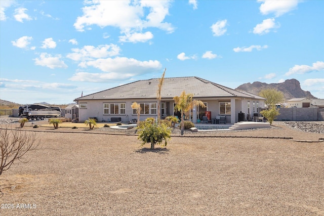 rear view of house featuring a mountain view and a patio