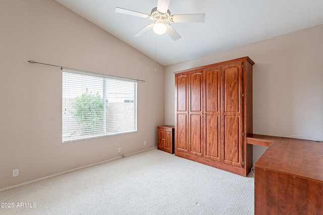 unfurnished bedroom featuring a ceiling fan, lofted ceiling, light colored carpet, and baseboards