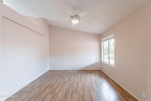 empty room featuring lofted ceiling, a ceiling fan, and wood finished floors