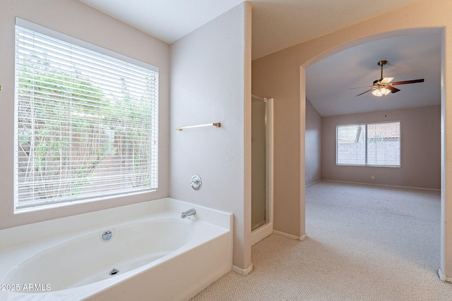 bathroom with a bath, a healthy amount of sunlight, a stall shower, and ceiling fan